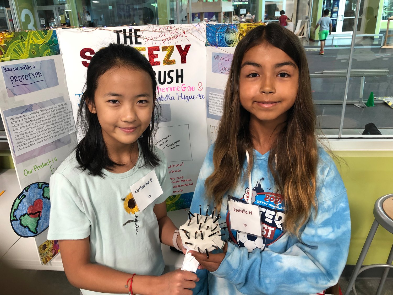 Katherine Gao and Isabella Higuera show a prototype of their squeezy scalp brush at the Inventors Summer Camp at the Robert Shaw Center.